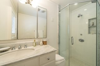 The home's sole bathroom features a luxe marble countertop.