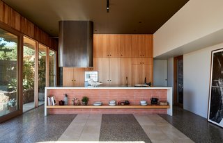 The kitchen's appliances are by Gaggenau, with track lighting by Masson Lighting. Fiona installed a shelf in the island so that the owners can personalize the space even more. 