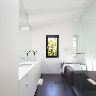 Porcelain floor tiles and Caesarstone countertops encompass the master bathroom, which also includes a pair of Duravit sinks and Aquabrass faucets. 