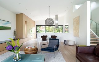 The newly opened kitchen, dining, and living space connect the home from front to back," Parish adds. "Operable windows on both ends allow for cross ventilation and unobstructed views, too." White oak millwork is shown throughout the space, including on the appliances. 