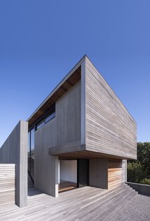 The east and west facades of the home feature mahogany siding, while the north and south facades are wrapped with bluestone siding.