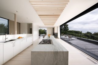 Masi flipped the design of a traditional home and placed the common areas on the second level for the best ocean views. The kitchen cabinetry is custom-made, and a Thermador range sits on the island. 