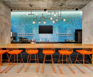 Techspace Austin's vibrant kitchen area features a custom bar designed by DoveTail Custom Woodworks.