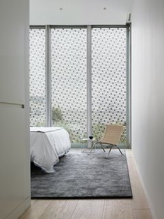 A Historic Victorian in San Francisco Is Meticulously Transformed Into a Modern Family Home - Photo 19 of 26 - The master bedroom, modest in size, features a Stark area rug and a wicker PK22 chair by Poul Kjærholm for Fritz Hansen.
