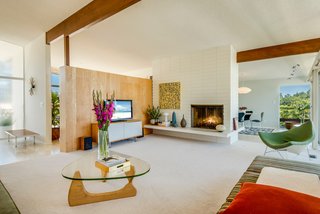 Original to the home, the large double-sided fireplace anchors the main floor's living room.