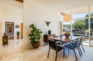 The partially-enclosed dining room faces the front of the home, where the expansive porch wraps around the entire property.