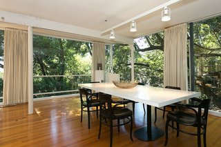 An Amazing Tree-Covered Glass House For Sale in the Berkeley Hills - Photo 3 of 20 - On the main level, the home's dining room is open to the living area and the outdoors.