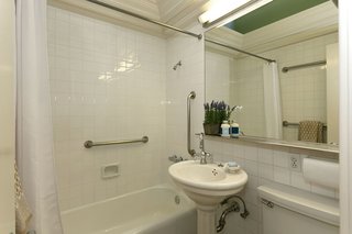 An Amazing Tree-Covered Glass House For Sale in the Berkeley Hills - Photo 17 of 20 - A full bathroom on the main living level is bright and functional.