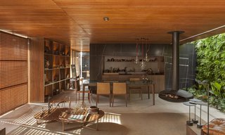 An Incredible Brazilian Home That Celebrates Art, Travel, and Nature - Photo 2 of 14 - The living area incorporates wood, marble, and porcelain, which mimics natural concrete—a material palette that's carried throughout the home.