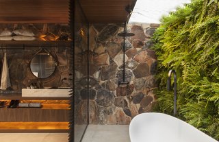 An Incredible Brazilian Home That Celebrates Art, Travel, and Nature - Photo 11 of 14 - Partially outdoors, the unconventional bathroom is a lush sanctuary.