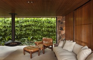 An Incredible Brazilian Home That Celebrates Art, Travel, and Nature - Photo 3 of 14 - The suspended fireplace anchors a cozy seating area.