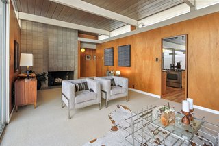 The original wood-burning, cinder-block fireplace remains intact, while clerestory windows allow light to pass between the kitchen and living room.