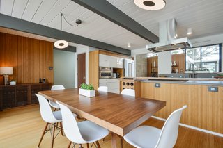 Warm wood tones dominate the open kitchen and dining area, with custom cabinetry by Redtail Woodworks.