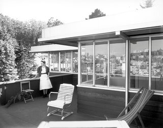 A 1950s photograph shows the upper-level terrace, remarkably consistent with architectural elements seen today.