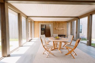 The transitional "bridge" connects the public social spaces to the more private sleeping quarters. One side of the bridge features cedar-clad walls, flush with the cedar siding on the barn, while the opposing side features the same local stone seen on the cottage.