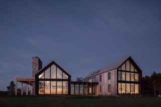 The Rose Coast Residence, illuminated at dusk, makes an impactful contribution to the unique coastal landscape, bravely looking towards the future.