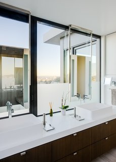 The bright master bedroom, with vessel sinks and Caesarstone counters, also enjoys sweeping city views.