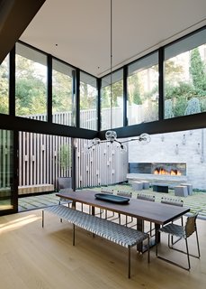 The double-height, fully glazed volume at the home's rear "brings significant light into the home, while simultaneously creating a moment to experience the verticality of the surrounding trees which loom above the home," explains Maniscalco.