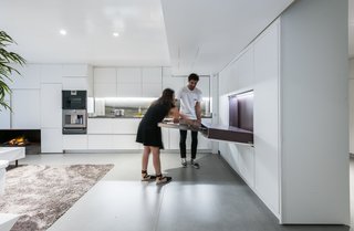 The dining table folds out from the wall to provide cozy seating for two, and it can be further extended to accommodate larger dinner gatherings for up to eight.