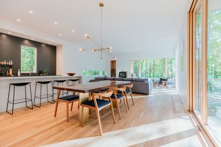The open kitchen and living room features a handcrafted walnut dining table designed by Marica, which sits beneath a brass chandelier she designed and built herself.
