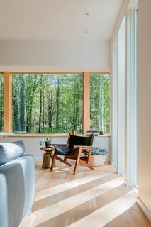 The south-facing facade, where the sun sets in the evening, is the couple’s favorite spot on the property. Creating expansive openings with this exposure allowed an intimate and inspiring connection with the wooded landscape.