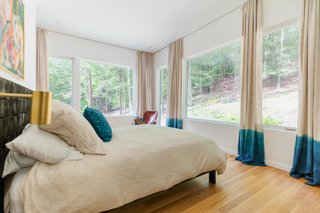 Marica hand-dyed the bedroom curtains three times with indigo to create the blue gradient. Adding to the symmetry and rhythm of the interior space, the color lines up perfectly with the sill of the windows.