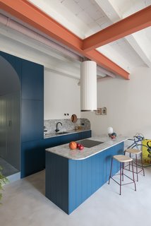 Hues of blue and coral create bold pops of color throughout the apartment. Painted coral I-beams follow the lines of what used to be partitions in the single, open space.