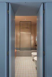The home's bathroom, at the center of the paneled "box" is a soft, private, and relaxing respite.