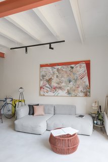 While Serboli preserved some period elements—namely the bedroom doors and floors—the living room floors could not be fully salvaged, largely due to the removal of several partitions. As such, the new floor is a continuous slab of ivory-colored micro-cement. The cozy living room features a Mags sofa and CAN chair, both by HAY, and a ZigZag stool from Kettal.