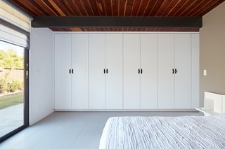 A wall-to-wall custom wardrobe offers smart storage.