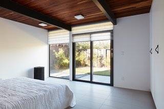 The spacious master bedroom enjoys plentiful light and direct access to the backyard.