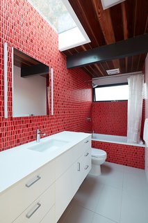 Client-selected Porcelanosa mosaic tile adds a pop of color to the guest bathroom.