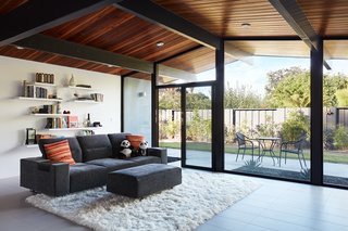 The clients wanted an open-concept living space, connected to the outdoors, where they would feel relaxed and centered. Klopf Architecture preserved the glass wall at the rear of the house while replacing the windows and doors with higher-efficiency Fleetwood models.