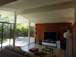 The original living room was open to the backyard, but separated from the rest of the house. The remodel removed the fireplace and partition walls to open up the space.