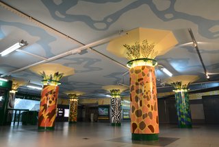 Santa Maria painted the zoo-inspired columns in the entrance of the Plaza Italia subway station. Intricate tile work at the top of each column features various types of foliage. 