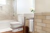 Modern home with Ceramic Tile Wall, Medium Hardwood Floor, Pedestal Sink, and Bath Room. Guest Photo 4 of 7th Avenue