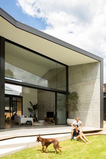 A look at the interior-to-exterior connections across a concrete terrace to the landscaped rear.