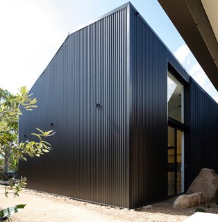 An opaque southern face mitigates significant overlooking from adjacent neighbors, while enabling a singular "shed" expression aligned to the home's coastal bush-like landscape.