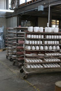 Formed, trimmed and glazed pieces wait to be fired on a ware cart.