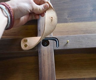 The single tool required for assembly is contained beneath a leather flap under the table. 
