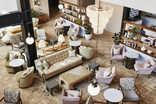 Light-toned parquet floors, a pastel palette, and Murano glass chandeliers contrast with steel structural elements in the living room-like lobby, which offers food and drink service.