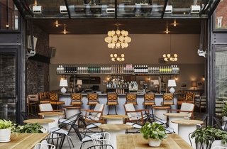 Backyard, the hotel's casual outdoor restaurant, is framed with blackened steel and brick structural elements that reference the neighborhood's industrial past.