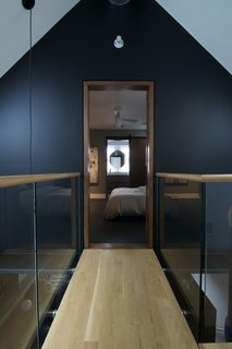 A catwalk runs between the guest and master bedrooms in this attic renovation. The white oak floors help the new attic level blend with the rest of the house.