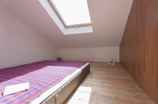 The ladder from the kitchen leads to this "sleeping box," a tucked-away room perfect for guests. The addition of a skylight brightens the space. 