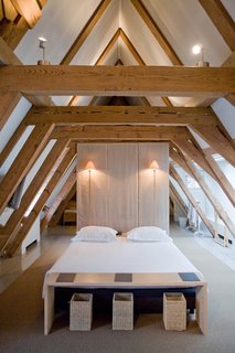 Giant wooden roof beams in the attic suite add to the peaceful and minimalist space.