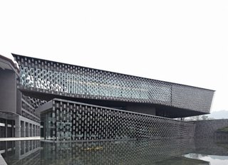 Locally-made tiles that are fixed tightly with stainless-steel wires create a curtain that covers the facade. 