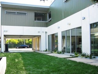 The concept for the project centers around educational, environmental, and fiscal responsibility. The 3,600-square-foot, two-story prefabricated house sits on a flat lot in an L-shape configuration.