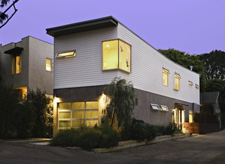This 16-foot-wide, four-steel framed module house has been carefully fitted into its 25-by-100-foot narrow lot. The lower floor is clad in light gray trowel stucco and the upper floor has horizontal Hardiplank, a green fiber cement siding.