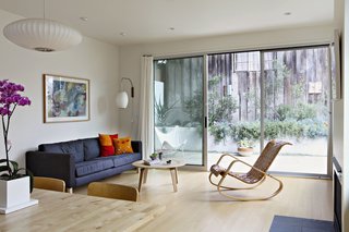The first floor contains a bright and airy open living/dining/kitchen space that faces a rear patio with large sliding glass doors. 