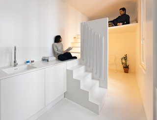 The Spectral Apartment by Betillon/Dorval-Bory Architects is a renovation of a 215-square-foot flat on the outskirts of Paris. Designed around the need to maximize natural light, the all-white interior features a mezzanine with a stairway leading up to a sleeping nook that conceals the sink and shower below. 